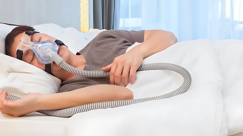 Person sleeping with CPAP machine to treat sleep apnea.