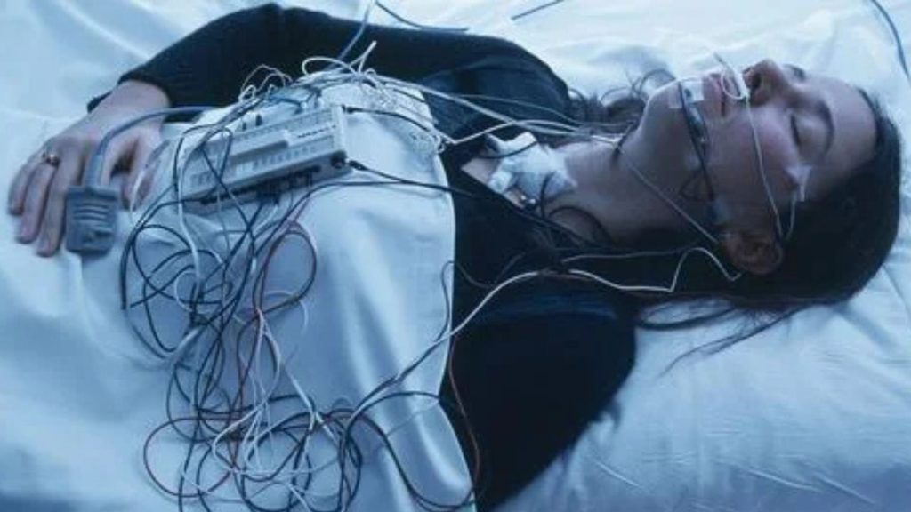 Woman undergoing a sleep study with monitoring equipment.